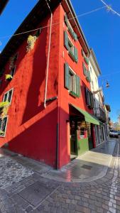 ein rotes Gebäude auf der Straßenseite in der Unterkunft Al Palazzetto in Udine