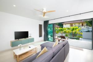 T villas في ثونغ نايبان ياي: غرفة معيشة مع أريكة ونافذة كبيرة