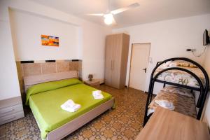a bedroom with a green bed and two bunk beds at Sea Salento Casa Vacanze in Punta Prosciutto