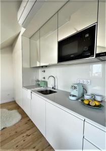 uma cozinha branca com um lavatório e um micro-ondas em Hey Studio - Free Parking and free Netflix em Aveiro