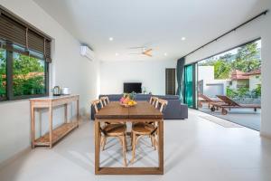 T villas في ثونغ نايبان ياي: غرفة معيشة مع طاولة وأريكة