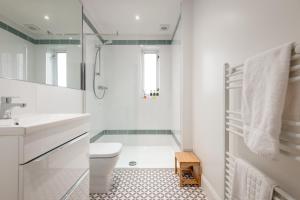 a white bathroom with a toilet and a sink at Chic Central 2 Bed Loft Apartment in St. Andrews