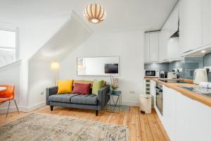 a living room with a couch and a kitchen at Chic Central 2 Bed Loft Apartment in St. Andrews