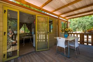 eine abgeschirmte Veranda mit einem Tisch und Stühlen auf einer Terrasse in der Unterkunft Tiliguerta Glamping&Camping Village in Costa Rei