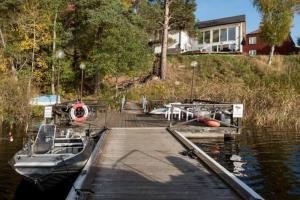 a boat is docked at a dock in the water at Exclusive House in Steninge Marina , Märsta in Märsta