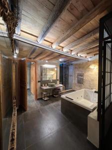 a large bathroom with a tub and a table at Guccia home in Palermo