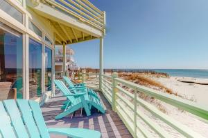 eine Veranda mit blauen Stühlen und Strand in der Unterkunft Dolphin View by Meyer Vacation Rentals in Gulf Shores