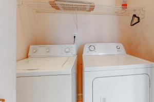een wasruimte met 2 witte apparaten en een wasmachine en droger bij Dolphin View by Meyer Vacation Rentals in Gulf Shores