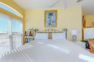 een groot wit bed in een kamer met een raam bij Dolphin View by Meyer Vacation Rentals in Gulf Shores