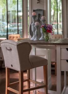 een eettafel met een stoel en bloemen bij Zenzez Hotel & Lounge in Apeldoorn