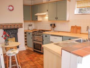 a kitchen with green cabinets and a stove top oven at 32 Church Hill in Telford