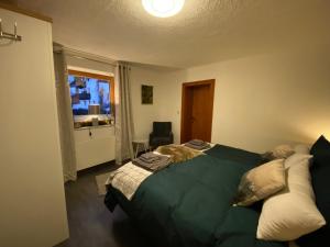 um quarto com uma cama verde e uma janela em Haus Ida em Ehrwald