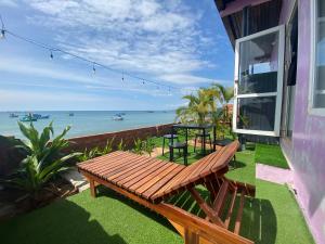 a porch with a bench and a table and the ocean at CHILL HOUSE by the beach in Phú Quốc