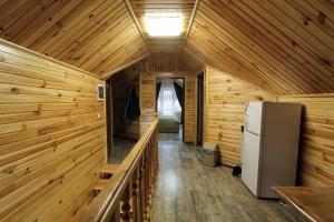 a wooden cabin with a refrigerator and a hallway at Melody Hotel in Bukovel