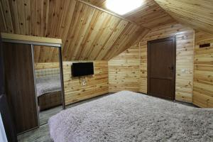 バコヴェルにあるMelody Hotelのベッドルーム1室(ベッド1台、木製の天井にテレビ付)