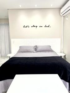 Un dormitorio con una cama con las palabras deja estar en la parte superior en Apto Loft Novo - Porto Belo - 5 min a pé da praia, en Porto Belo