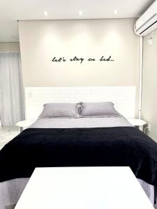 a bedroom with a bed with the words lets stay on top at Apto Loft Novo - Porto Belo - 5 min a pé da praia in Porto Belo