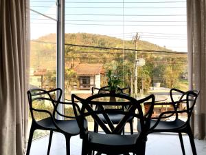 una mesa y sillas sentadas frente a una ventana en Apto Loft Novo - Porto Belo - 5 min a pé da praia, en Porto Belo