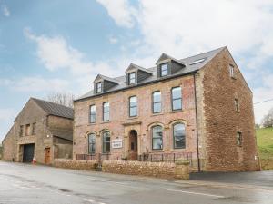 a large brick building with a black roof at Howgills in Kirkby Stephen