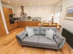 a living room with a couch and a kitchen at Howgills in Kirkby Stephen