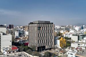 a tall building in the middle of a city at Pullman Lima Miraflores in Lima