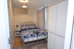 Schlafzimmer mit einem Bett mit blauer und weißer Bettwäsche in der Unterkunft Cheerful 4 bedroom House in greater London in London
