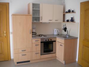 uma cozinha com armários de madeira e um forno com placa de fogão em Gästehaus Jedinger em Sankt Georgen im Attergau