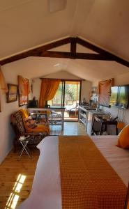 a living room with a bed and a kitchen and a room at Jamais le même in Kakamas