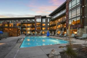 an apartment complex with a swimming pool in front of a building at Luxury 2 BR in Canyons Village - Walk to Slopes in Park City