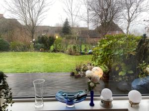 a view of a garden from a window with a table at An der Marsch in Alkersum