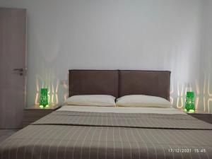 een slaapkamer met een bed met 2 groene lampen bij Ca'Claudia Boavista in Sal Rei