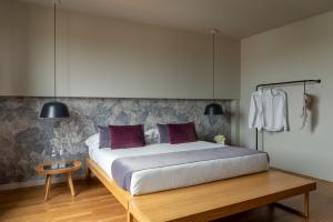 ヴェローナにあるホテル レオパルディのベッドルーム(大型ベッド1台、木製テーブル付)