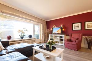 a living room with a couch and a tv at Bens Hüs in Braderup