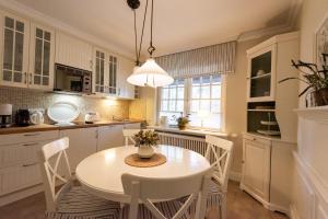 a kitchen with a white table and chairs at Bens Hüs in Braderup