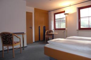 ein Hotelzimmer mit zwei Betten, einem Tisch und Stühlen in der Unterkunft Hotel Sonne in Wolfach