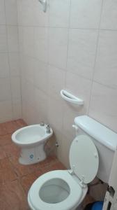 a bathroom with a white toilet and a sink at DEPARTAMENTO CON COCHERA in La Rioja +13 photos