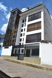 a tall white building with a black fence at Apu Wasi in Cusco