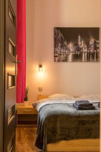a bedroom with a bed and a painting on the wall at Koletek st Apartment in Krakow
