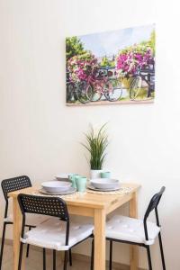 a dining room table with chairs and a painting on the wall at Koletek st Apartment in Krakow