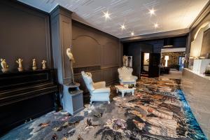 a lobby with a piano and chairs and a rug at Cit'Hotel B Hotel in Béthune