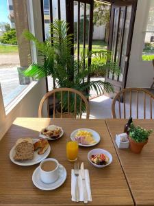 a table with plates of breakfast food on it at Hotel Puerta del Sol Pinamar in Pinamar