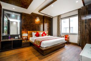 アムリトサルにあるAmritsar Grand By Levelup Hotels 100 meters from golden templeのベッドと鏡が備わるホテルルーム