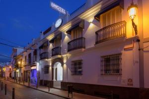 un edificio con un reloj al costado. en Hotel Boutique Sibarys - Adults Recommended, en Nerja