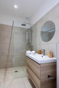 een badkamer met een wastafel en een douche met een spiegel bij Casa Marina Cargèse in Cargèse