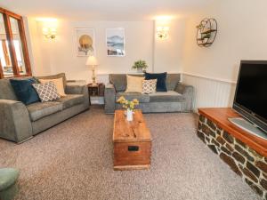 a living room with two couches and a tv at Beechcroft Cottage in South Molton