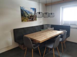a dining room with a wooden table and chairs at Haus Renswouw in Hollersbach im Pinzgau