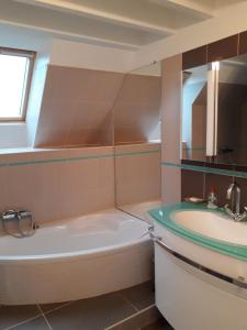 ein Badezimmer mit einer Badewanne und einem Waschbecken in der Unterkunft Gîte La Bulle En Baie, proche Mont Saint-Michel, au calme, pour 4 pers in Crollon