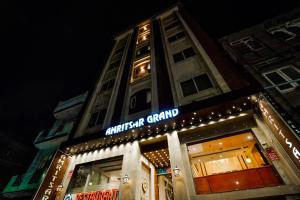 阿姆利則的住宿－Amritsar Grand By Levelup Hotels 100 meters from golden temple，前面有标志的建筑