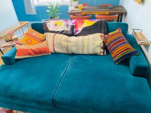 Un sofá azul con mantas y almohadas. en Boho-Chic Travel Pad - Unit 2, en Bloomington