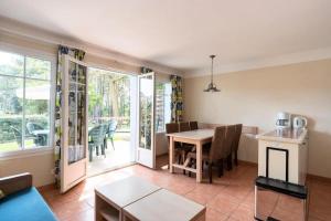 a living room with a table and a dining room at Maison sur golf avec piscine chauffée à Lacanau Océan in Lacanau